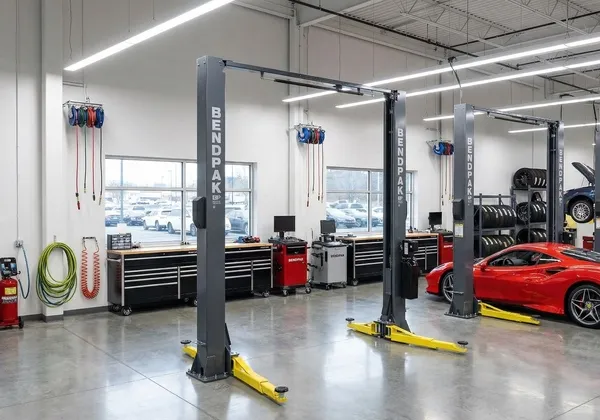 Two-post vehicle lifts in a clean service bay with a sports car