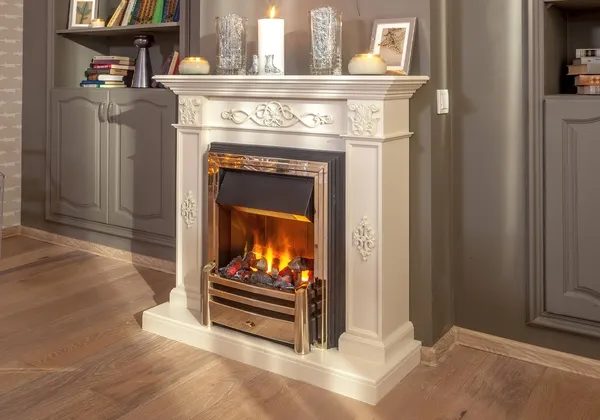 An electric fireplace insert in a white classical mantel