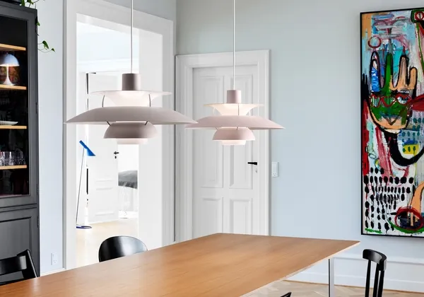 Two pendant lamps hanging over a dining table in a bright room