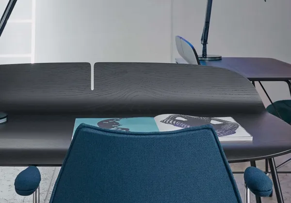 A dark wood desk with a blue upholstered office chair
